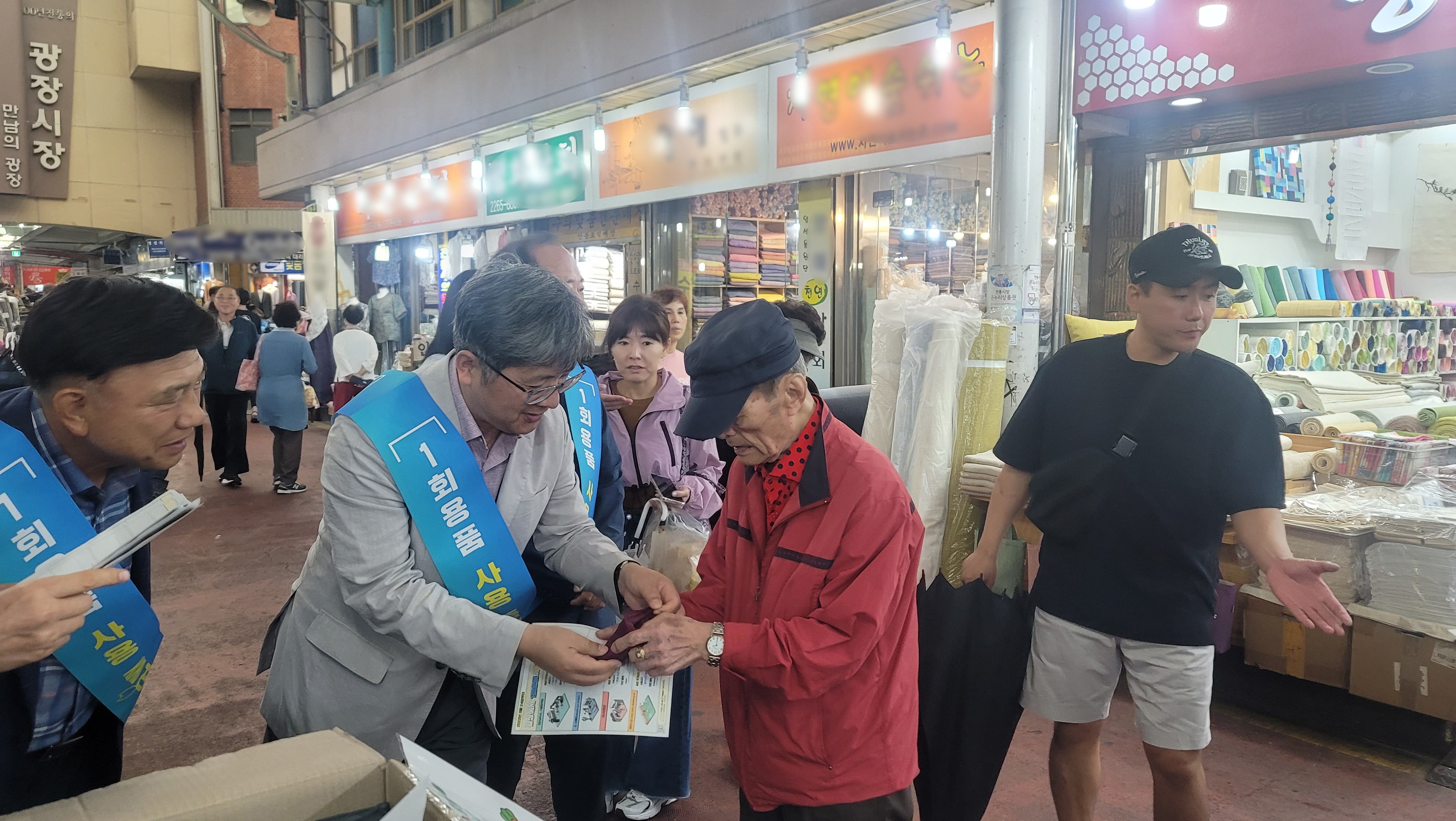 김승희 한강유역환경청장(왼쪽에서 두번째)이 9월 26일, 종로구 광장시장에서 방문객에게 장바구니를 나눠주고 있다